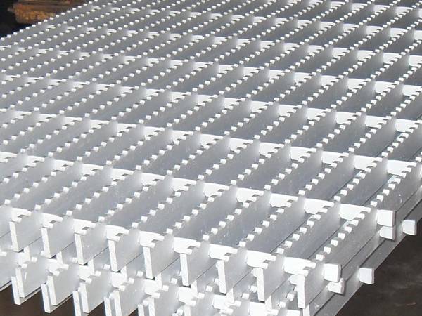 A pile of aluminum gratings is placed on the ground.