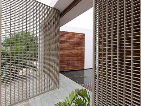 The steel grating gate is open and the plants are beside it.