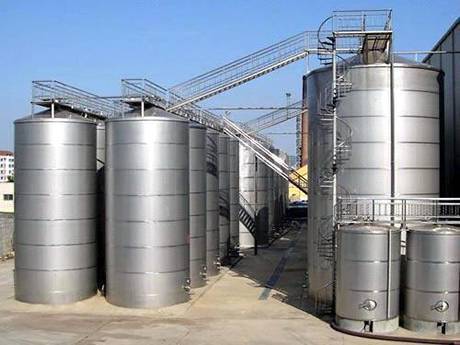 There are many oil storage tanks on the ground, and steel grating stairs and floor for tanks.