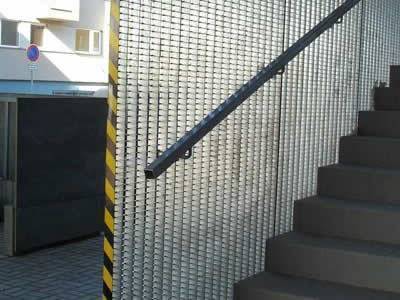 Steel grating panels separate the stairs from the outdoor area.