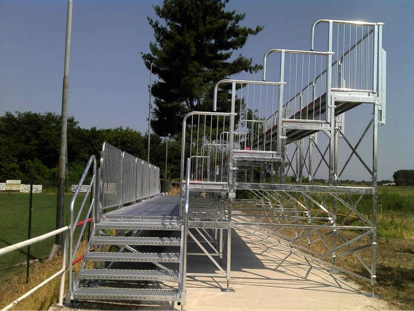 A four-layer stands with five-layer stairs was placed on the road which both sides are grass.