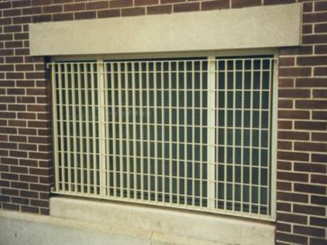 This is a wall of house with steel grating window.