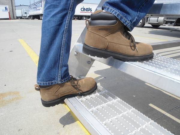 A man is stepping at swage locked grating stair treads.