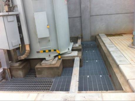 Transformer reservoir steel grating is used as floor in power station.